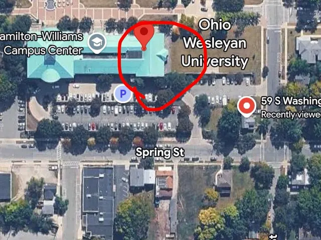 Satellite map of Ohio Wesleyan: the Benes Room end of the Hamilton-Williams Campus Center circled in red, the parking lot right below it and Spring St along the bottom of the lot.